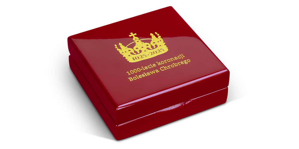 Drewniane, lakierowane pudełko z miękkim, czarnym wypełnieniem. Na jego wieku wygrawerowano jubileuszowe logo z okazji 1000. rocznicy koronacji Bolesława Chrobrego.